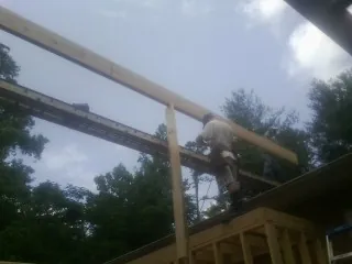 Carpenter setting a ridge beam over a new addition frame — Ice Dam Removal by Roofing Brothers in Warrensburg