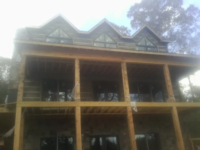 Dormers and porch framing on a large log home under construction — Roof Coating work by our crew in Warrensburg